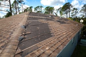 House Roof With Missing Shingles After Hurricane Ian In Florida. Consequences Of Natural Disaster