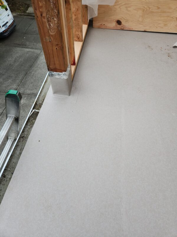 Rotted siding beneath gutter line exposed by crew – Dry rot discovered behind siding during Portland roof repair project.