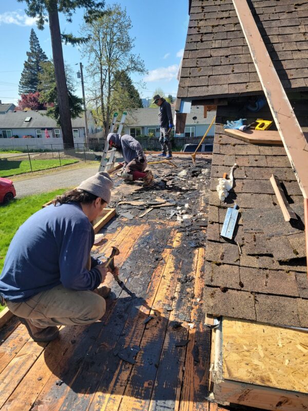 Mike’s crew inspecting soft roof decking on flat roof before teardown