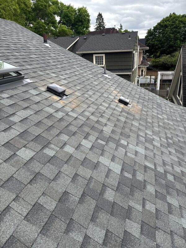 Twin roof vents with fresh install debris showing signs of attic heat buildup